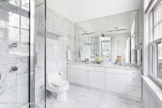 a bathroom with a granite countertop sink toilet a mirror and shower