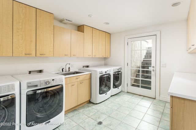 a utility room with sink dryer and washer