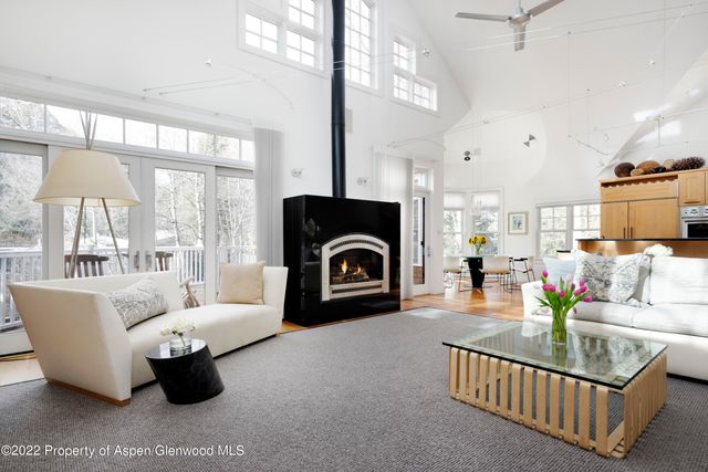 a living room with fireplace furniture and a large window