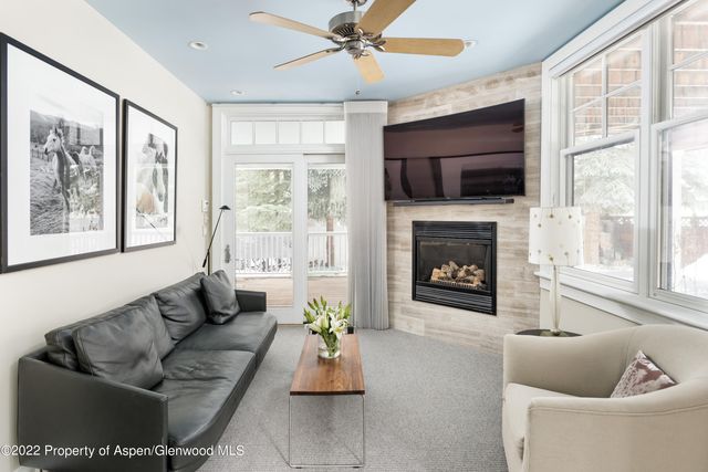 a living room with furniture a flat screen tv and a fireplace