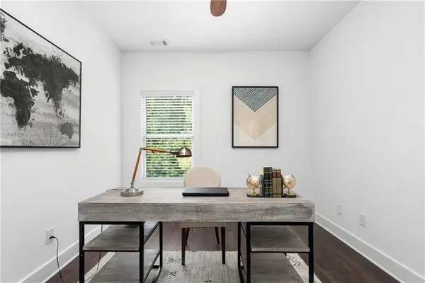 a view of a house with a small yard and large trees