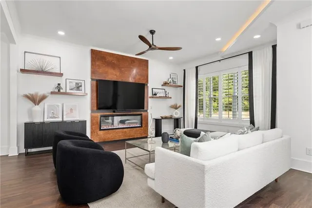 a living room with furniture a ceiling fan and a flat screen tv
