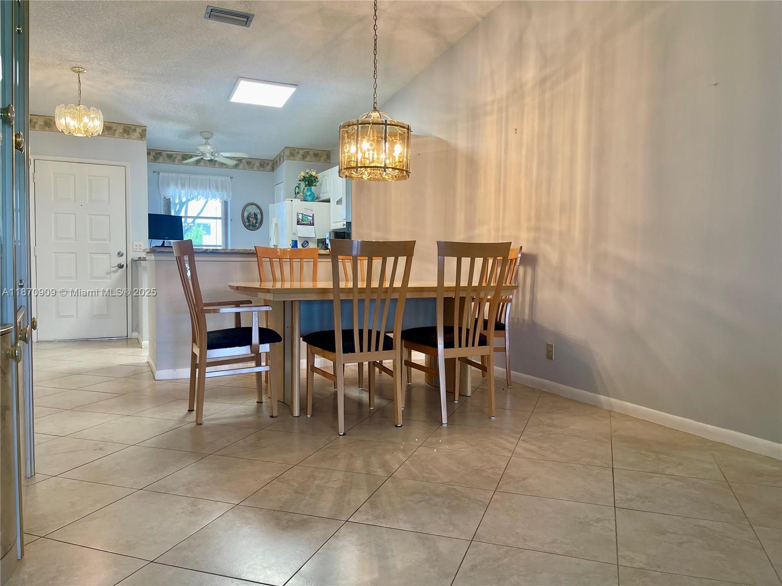 8633 Sunbird Place Boca Raton, FL 33496 - Photo 4 of 23 a view of a dining room with furniture and chandelier
