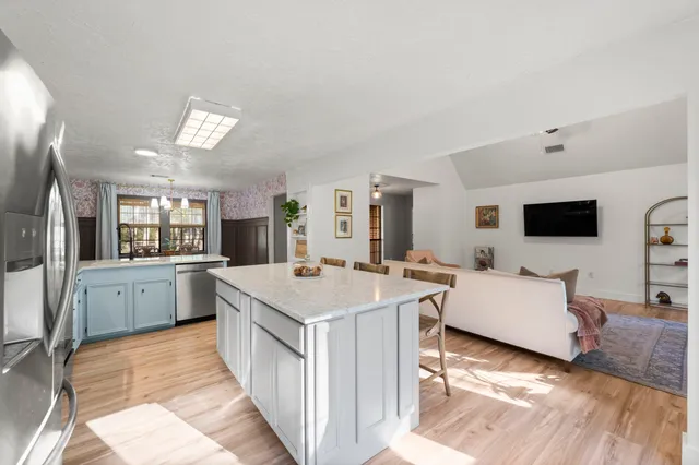 a kitchen with a table chairs and wooden floor