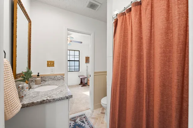 a living room with furniture a flat screen tv and kitchen view