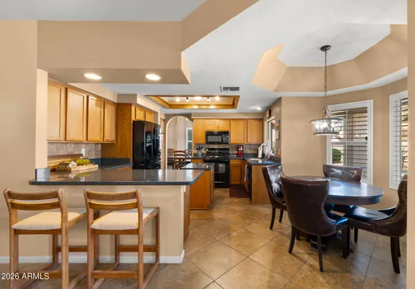 a kitchen with stainless steel appliances granite countertop sink stove refrigerator and cabinets