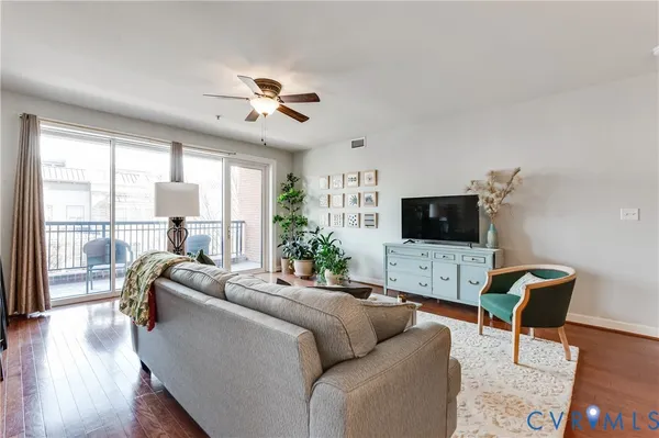 a living room with furniture a flat screen tv and a large window