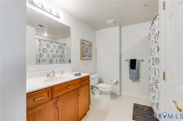 a spacious bathroom with a toilet sink and mirror