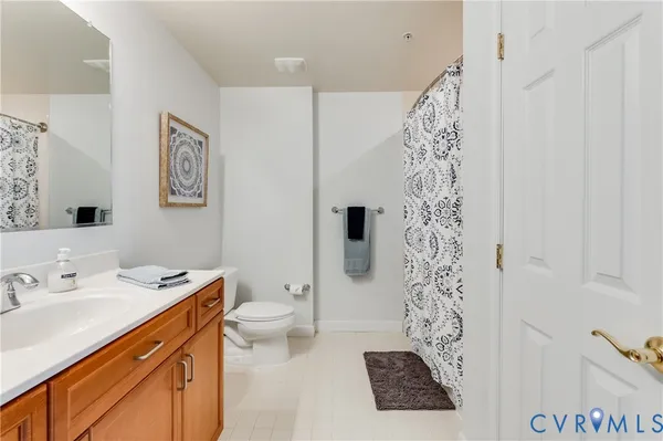 a bathroom with a sink a toilet and shower curtain