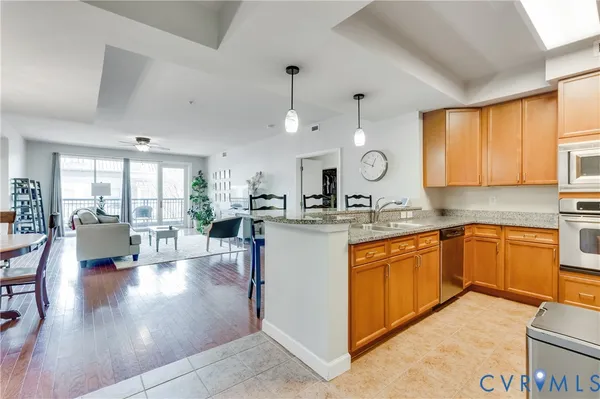 a large kitchen with stainless steel appliances lots of counter space and living room