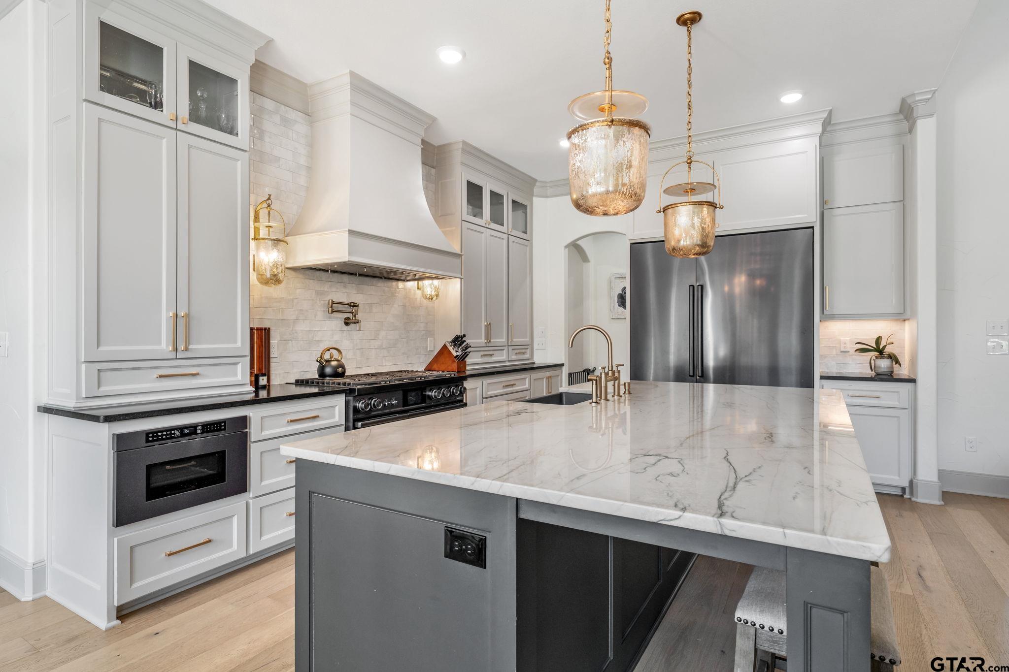 15601 Stampede Run Tyler, TX 75703 - Photo 15 of 48 a kitchen with stainless steel appliances a stove a sink and a refrigerator
