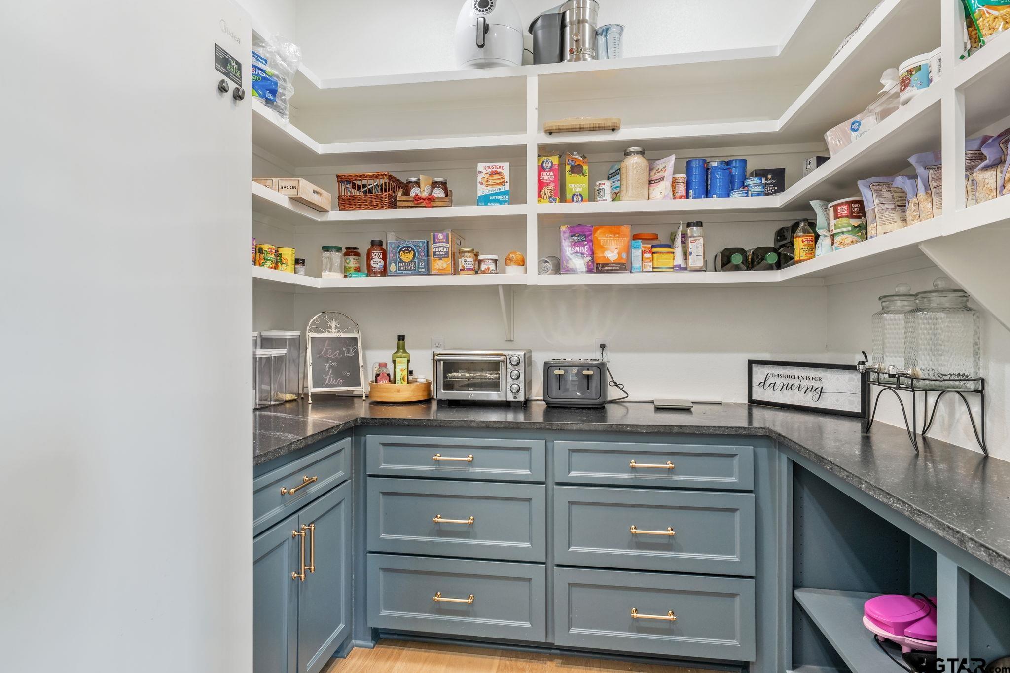 15601 Stampede Run Tyler, TX 75703 - Photo 19 of 48 a kitchen with a cabinets and a shelf with books