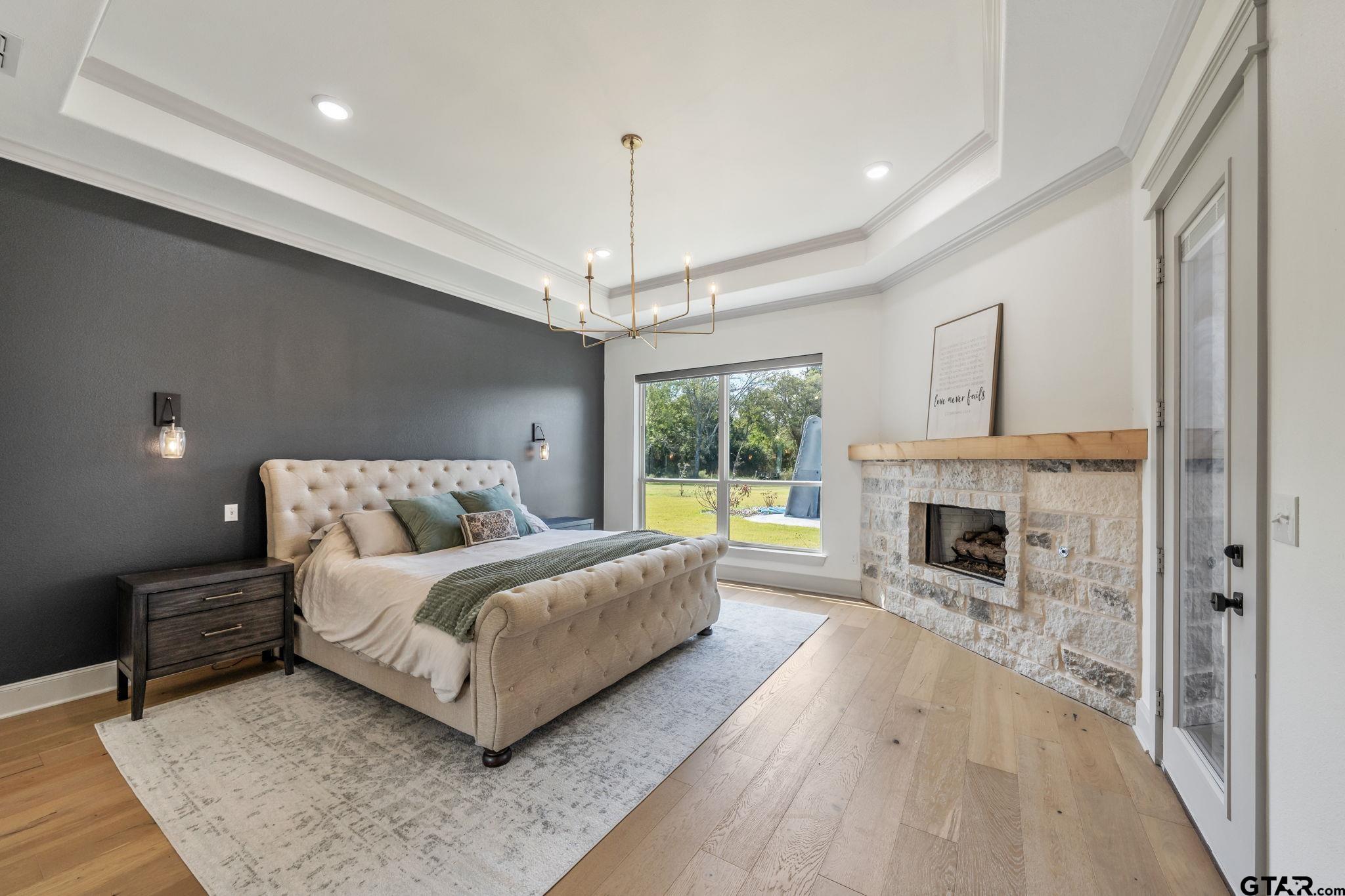 15601 Stampede Run Tyler, TX 75703 - Photo 20 of 48 a spacious bedroom with a large bed and a fireplace