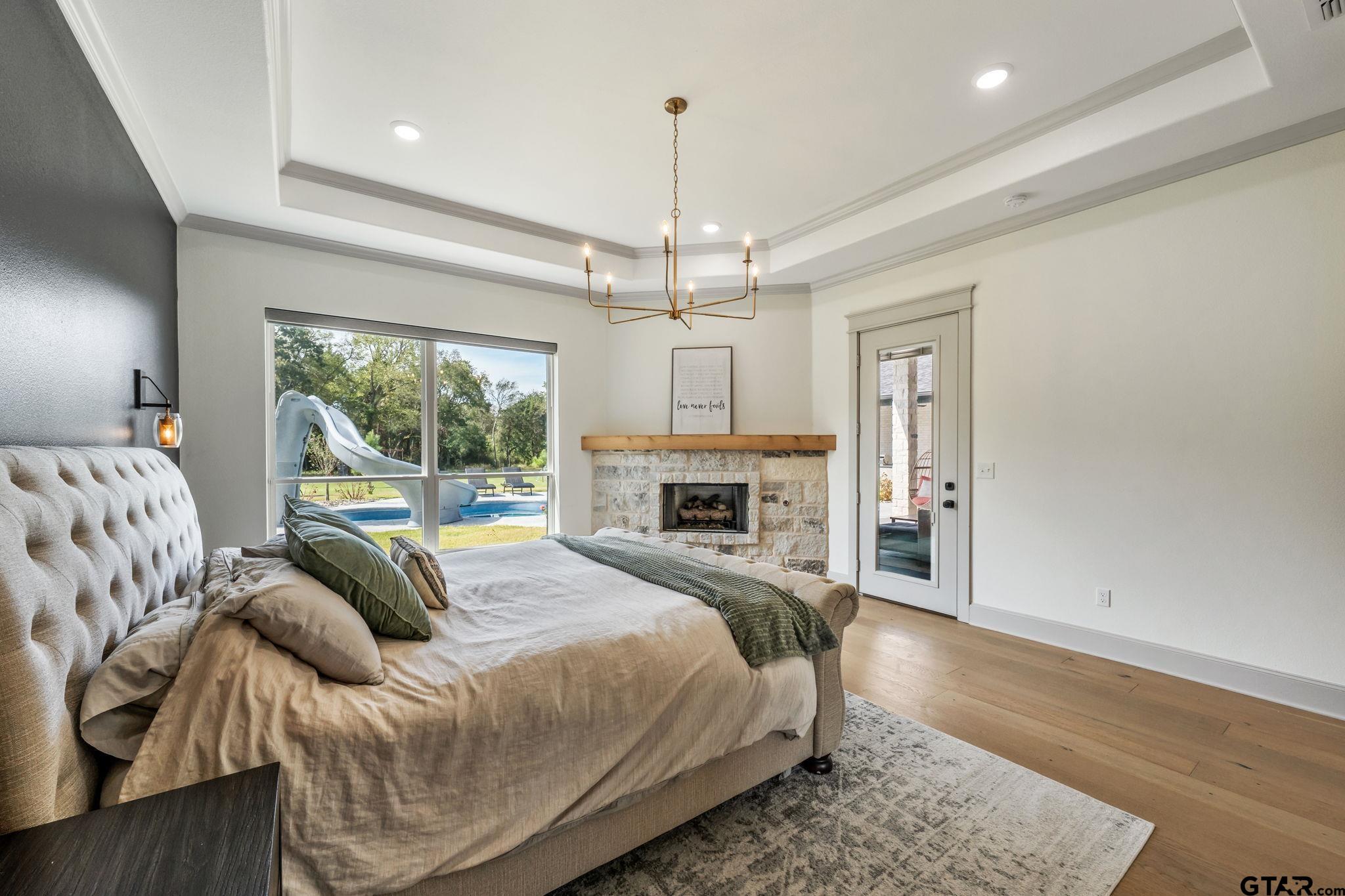 15601 Stampede Run Tyler, TX 75703 - Photo 22 of 48 a spacious bedroom with a bed and a chandelier