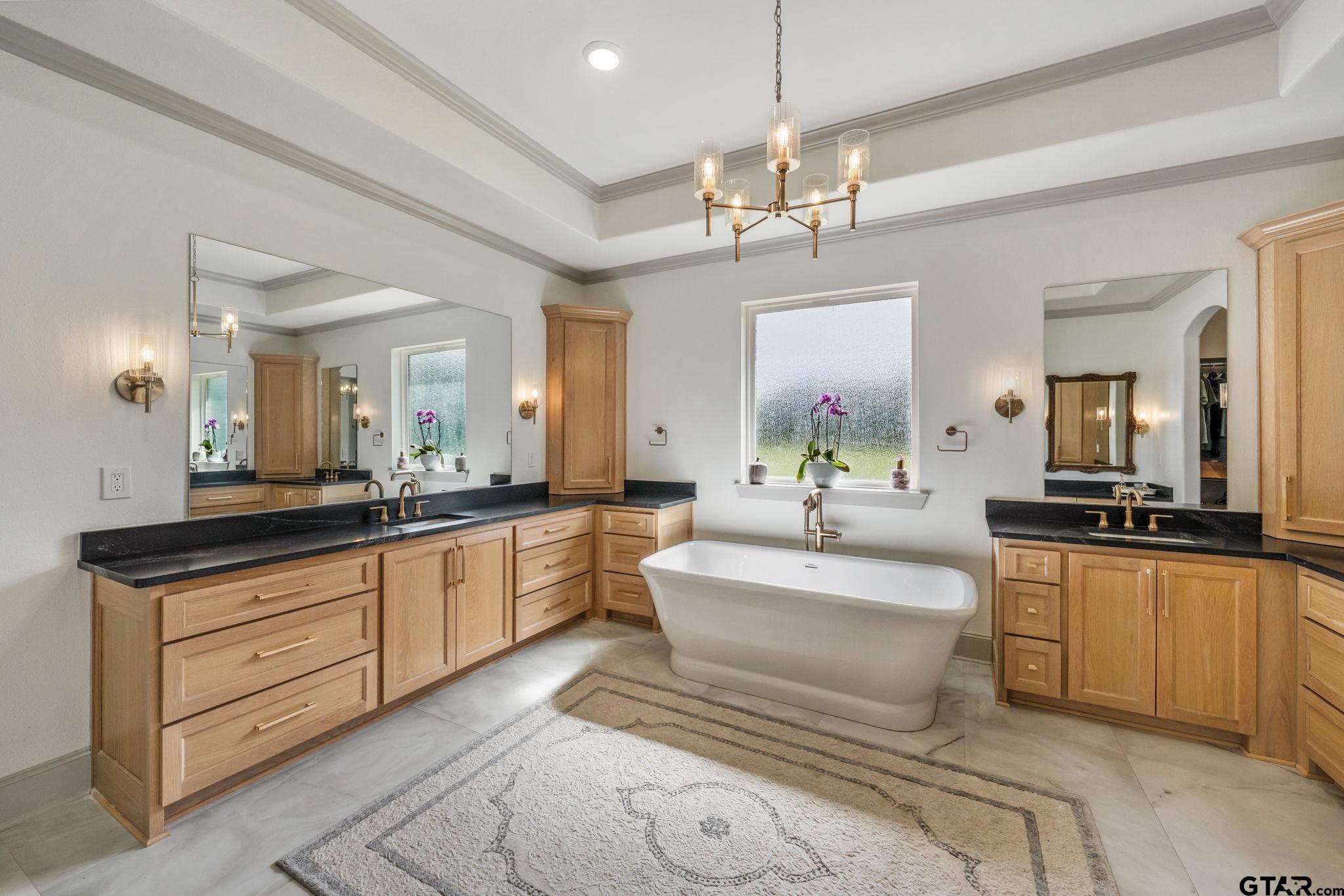 15601 Stampede Run Tyler, TX 75703 - Photo 24 of 48 a spacious bathroom with a double vanity sink a mirror a bathtub and a shower