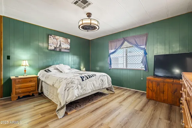 a bedroom with a bed and a flat screen tv