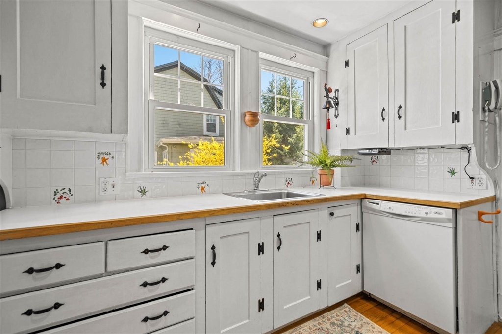 71 Woodside Road Winchester, MA 01890 - Photo 21 of 40 a kitchen with white cabinets and window