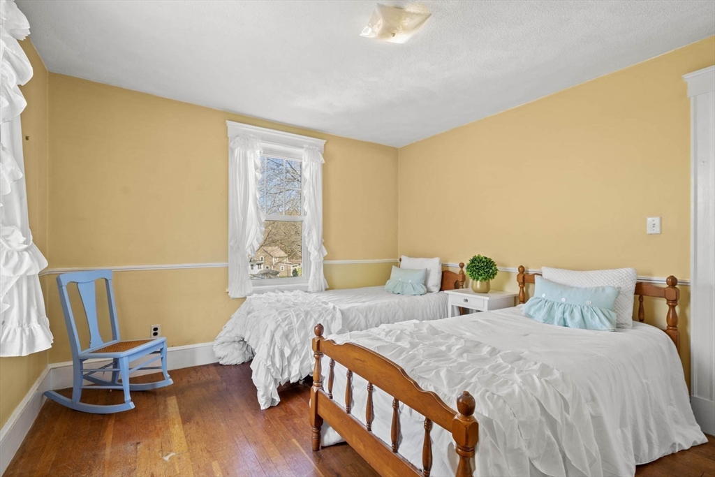 71 Woodside Road Winchester, MA 01890 - Photo 28 of 40 a bedroom with a bed and wooden floor