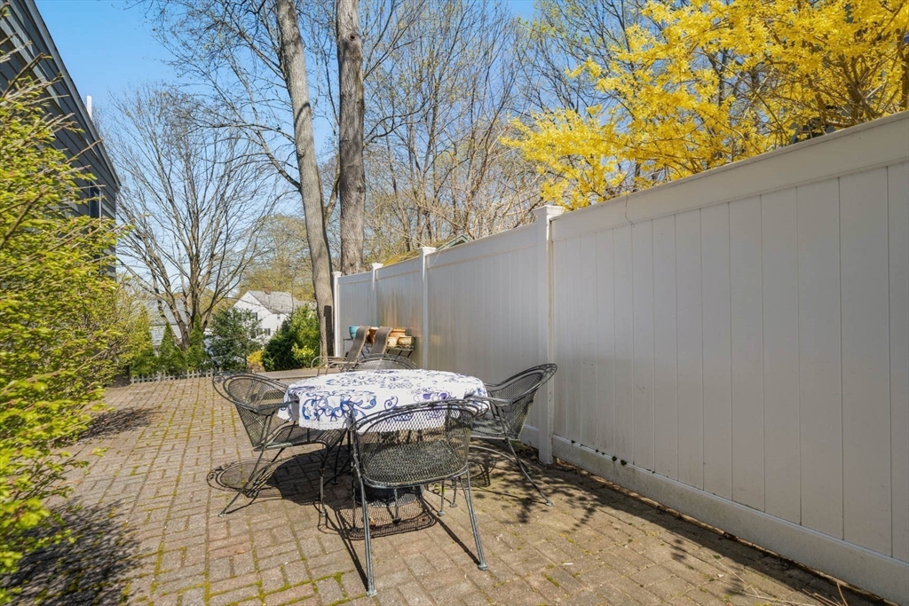 71 Woodside Road Winchester, MA 01890 - Photo 32 of 40 a patio with table and chairs and potted plants