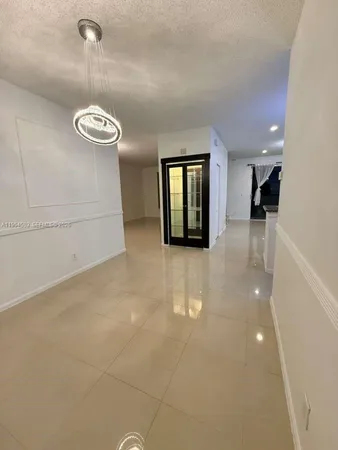 an empty room with wooden floor and a hallway