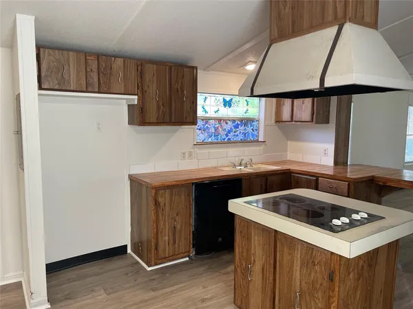 a kitchen with a sink cabinets and wooden floor
