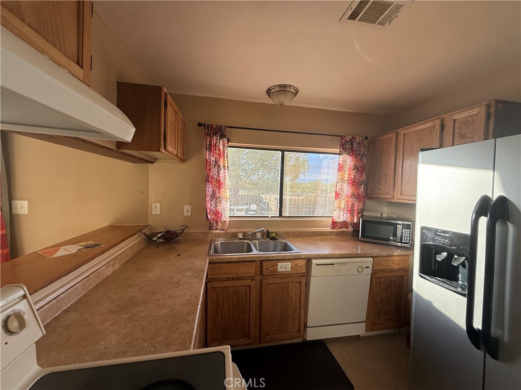 243 Balboa Avenue Mojave, CA 93501 - Photo 52 of 75 a room with a table chairs and a refrigerator