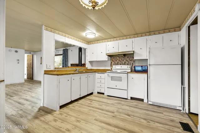 a kitchen with white cabinets and white appliances