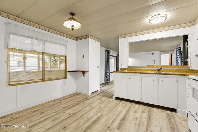 a view of a kitchen with a sink and cabinet with wooden floor