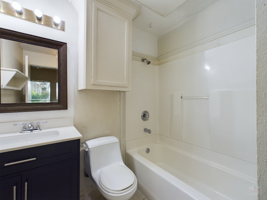 114 East 31st Street, Unit 113 Austin, TX 78705 - Photo 15 of 18 a bathroom with a bathtub toilet sink vanity and mirror