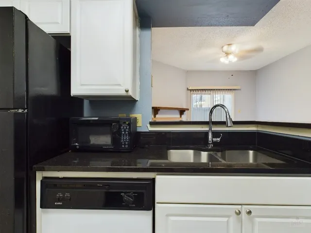 a kitchen with stainless steel appliances granite countertop a sink and a stove