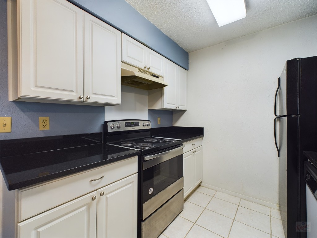 114 East 31st Street, Unit 113 Austin, TX 78705 - Photo 8 of 18 a kitchen with granite countertop a stove and a refrigerator