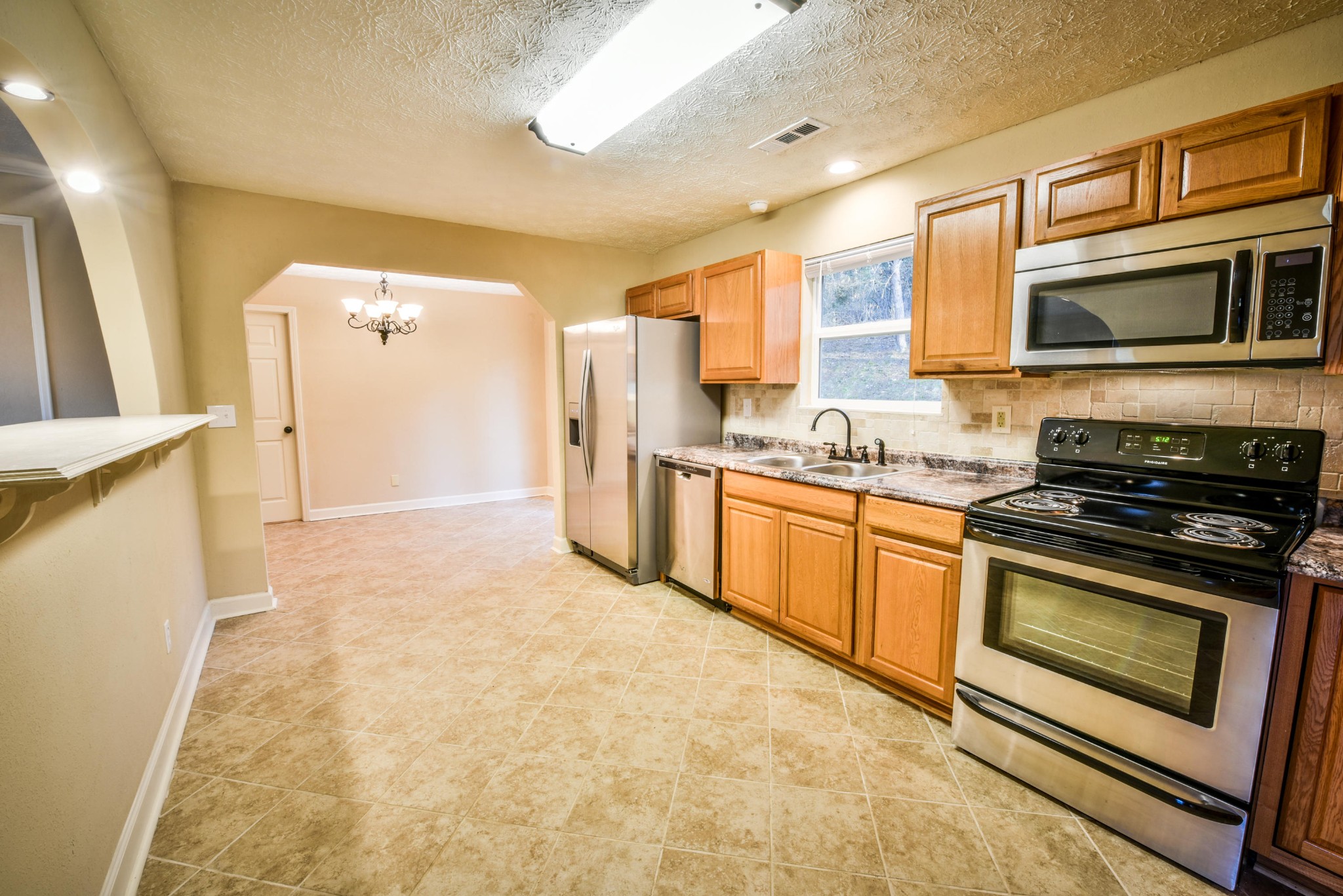 3984 Bent Road Kodak, TN 37764 - Photo 13 of 21 a kitchen with stainless steel appliances granite countertop a stove a sink and a microwave