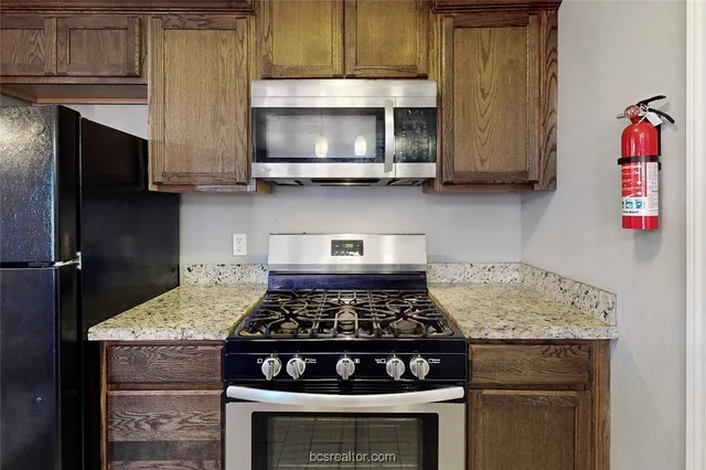 a kitchen with stainless steel appliances granite countertop a stove and a microwave