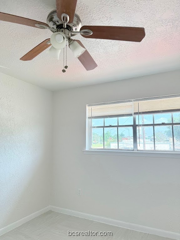 3300 South College Avenue, Unit F11 Bryan, TX 77801 - Photo 6 of 7 Spare room featuring a textured ceiling and ceiling fan