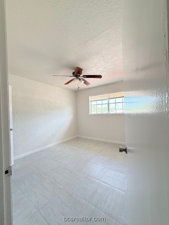 3300 South College Avenue, Unit F11 Bryan, TX 77801 - Photo 7 of 7 Unfurnished room featuring a textured ceiling and a ceiling fan