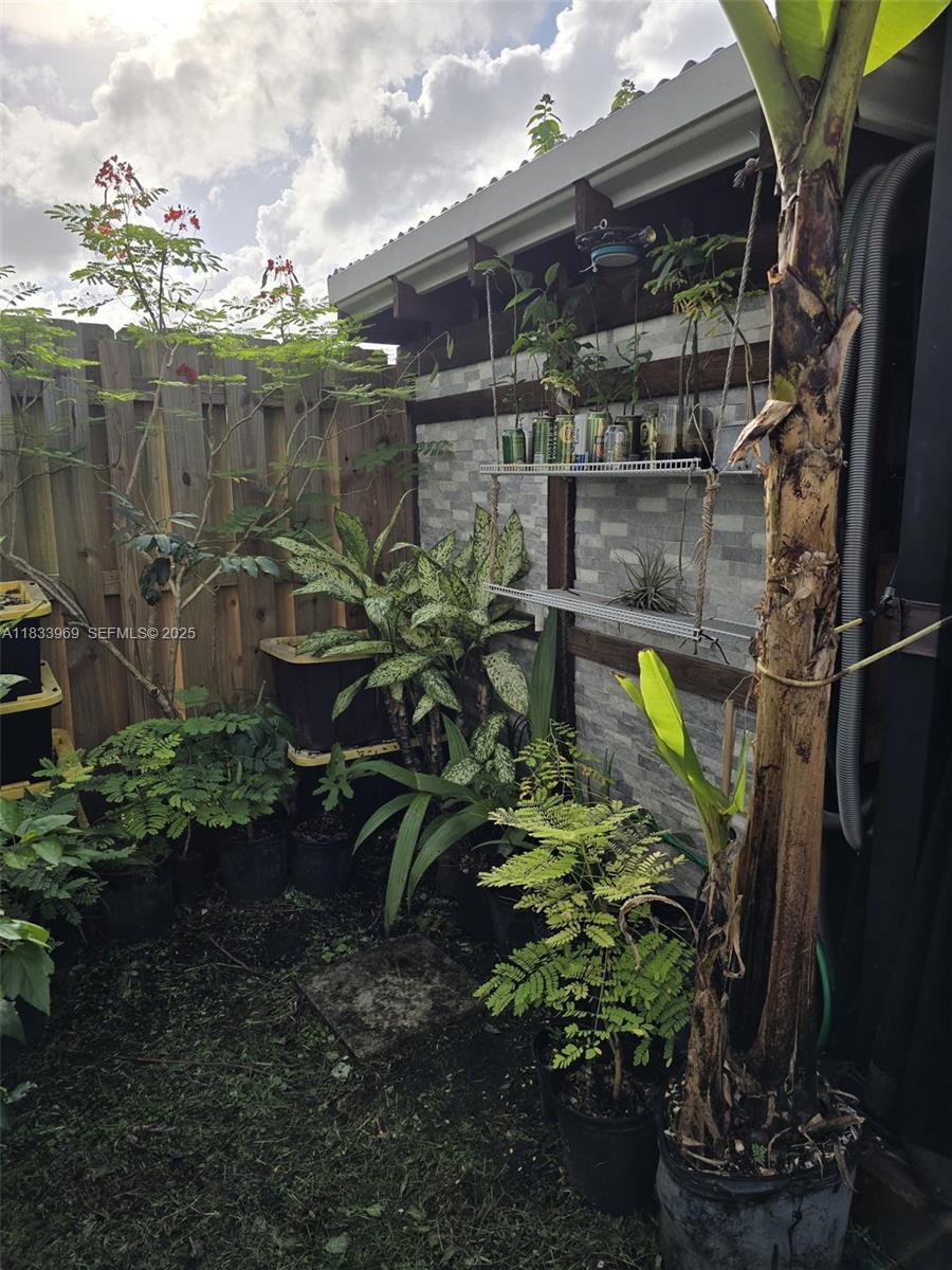 18264 Southwest 148th Road, Unit 18264 Miami, FL 33187 - Photo 22 of 25 a backyard of a house with a garden and outdoor seating