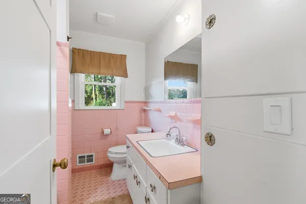 a bathroom with a sink a toilet and mirror
