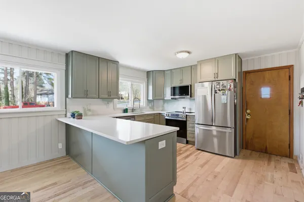 a kitchen with stainless steel appliances granite countertop a sink stove and refrigerator