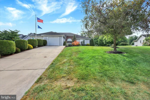 a front view of a house with a yard and trees