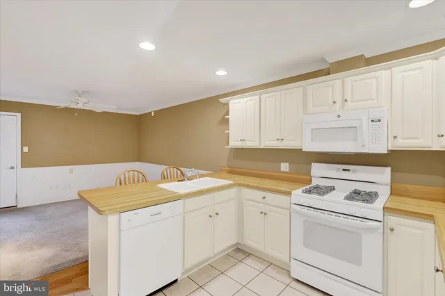 a kitchen with white cabinets sink and white appliances