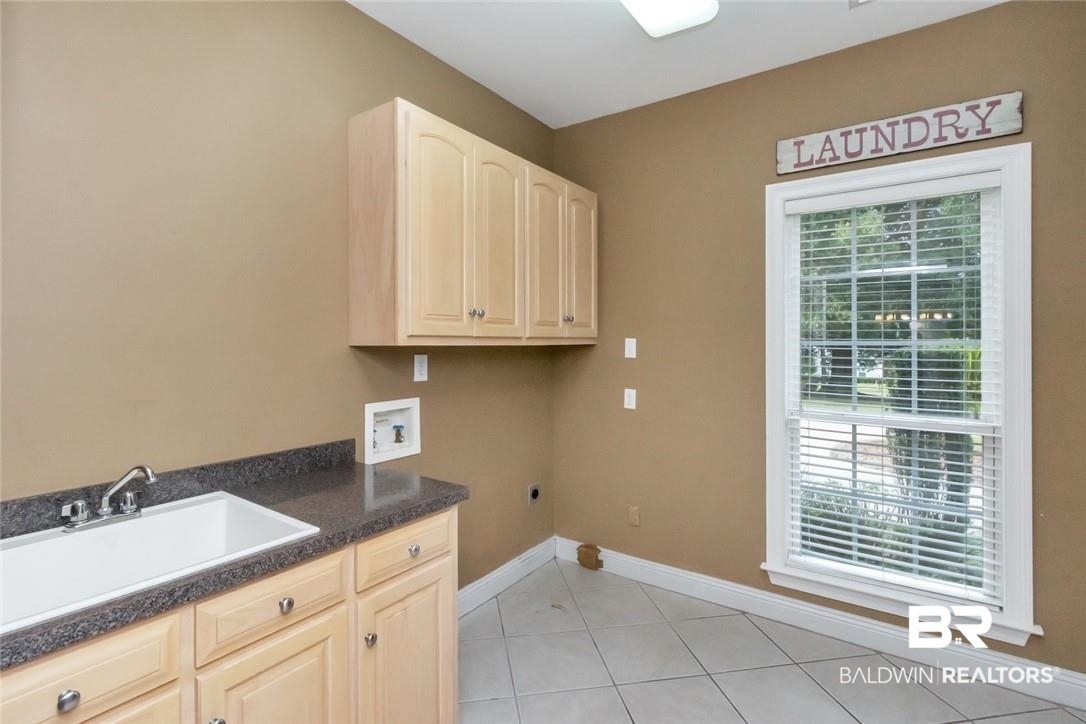 8837 Dawes Lake Road South Mobile, AL 36619 - Photo 32 of 44 Laundry room with hookup for a washing machine, cabinets, sink, hookup for an electric dryer, and light tile patterned flooring