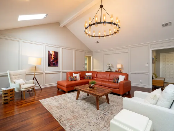 a living room with furniture a dining table and a chandelier