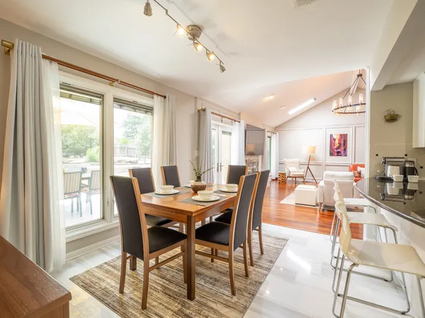 a view of a dining room and livingroom with furniture wooden floor and a rug