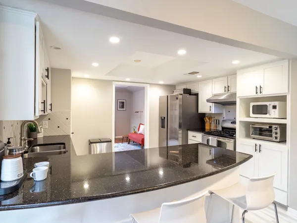 a kitchen with stainless steel appliances granite countertop a sink a stove and a refrigerator