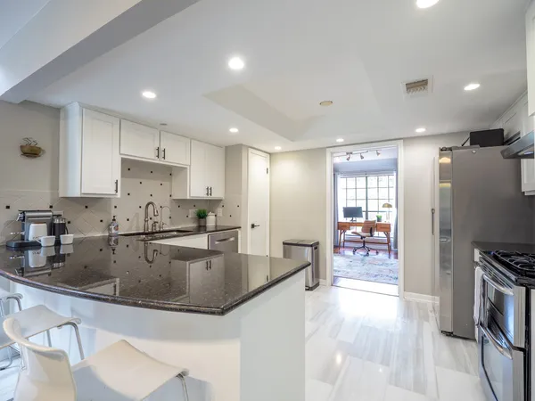 a kitchen with stainless steel appliances granite countertop a sink refrigerator and cabinets