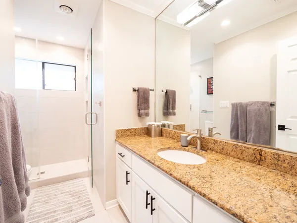 a bathroom with a granite countertop sink and a mirror