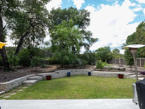 a house view with swimming pool and trees in the background