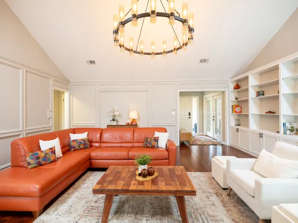a living room with furniture a rug and a chandelier