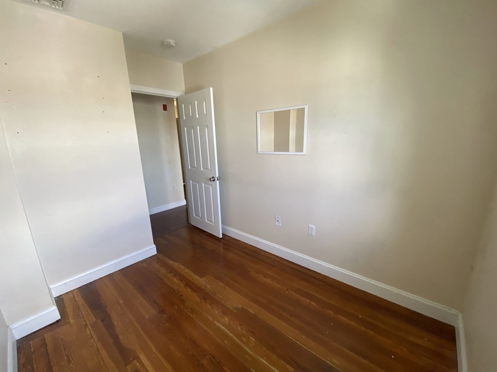 191 Everett Street, Unit 2 Boston, MA 02128 - Photo 2 of 6 an empty room with wooden floor and entrance