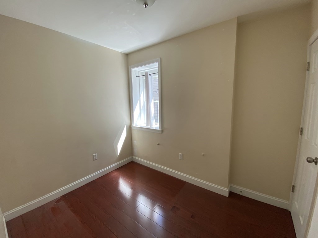 191 Everett Street, Unit 2 Boston, MA 02128 - Photo 4 of 6 an empty room with wooden floor and windows